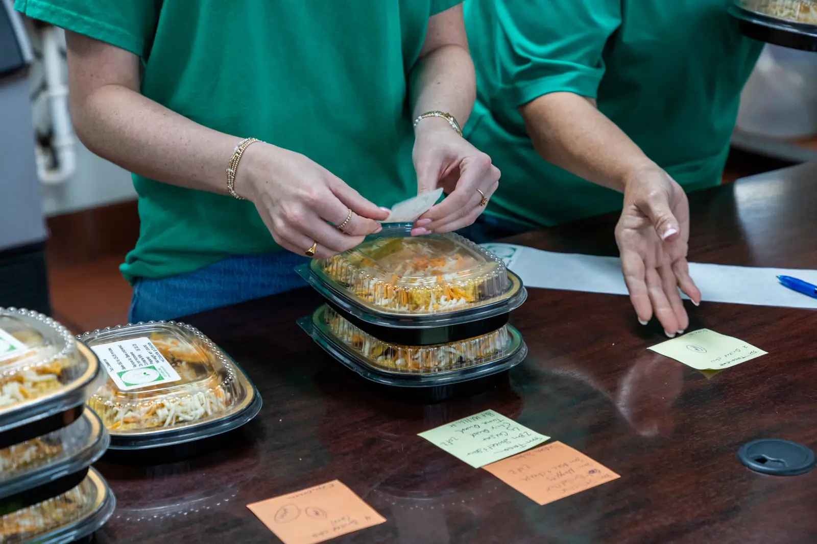 Staff labelling the day’s prepared meals-to-go trays